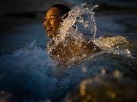 MinhTu in the Waves at Sundown : Maya Breeze Inn Placencia : Belize